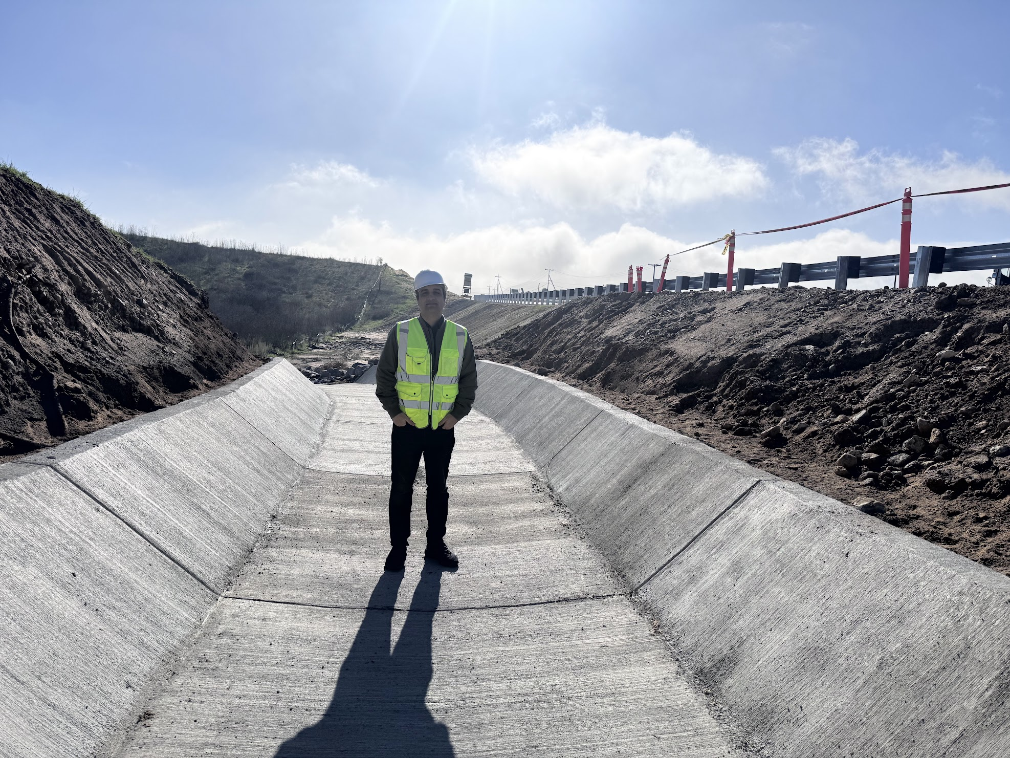 Farhang Jalali inspecting a concrete drainage channel on a civil construction site